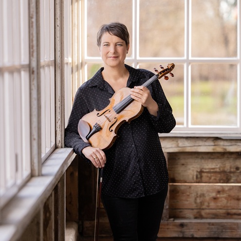 Stefanie Pagnia hält ihre Geige im Arm und steht im Bahnhof Fellheim