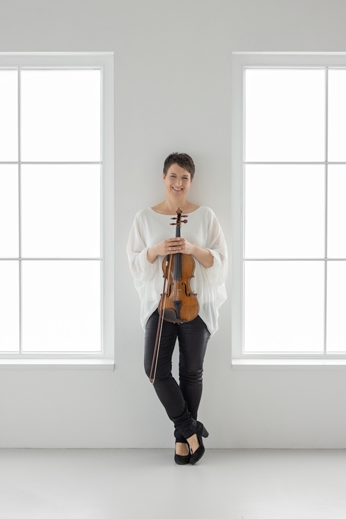 Stefanie Pagnia steht an eine Wand angelehnt und lächelt